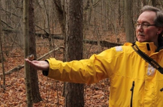 Legacy donor Vicki Smith with a downy woodpecker in Cottonwood Island Park, in Prince George, B.C.